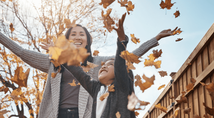 girl and woman throwing leaves in air